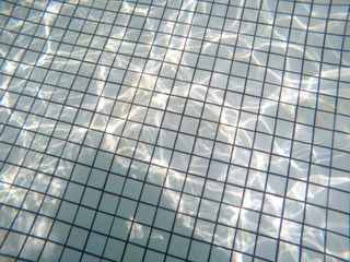 underwater view of swimming pool floor with sunlight reflections. concept of leisure activities