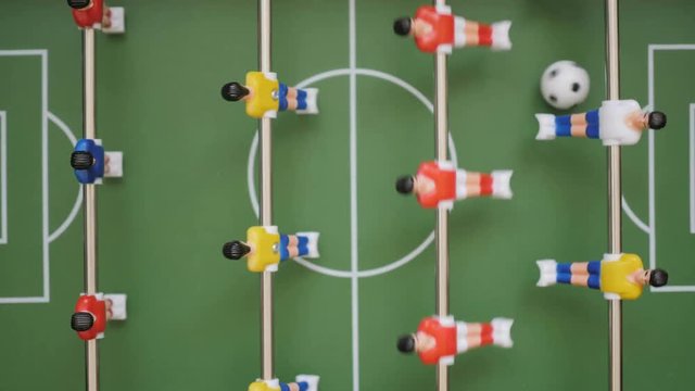 Friends Playing Table Soccer Game Closeup. People playing in table football or kicker with miniature players. Slow Motion. Shallow DOF. Playing Football Soccer on game table. Close Up.