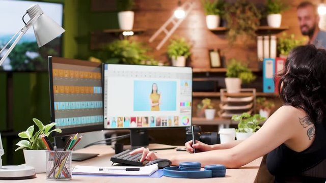 Female photo editor ask her colleague for help. She uses professional photo editing software or applications