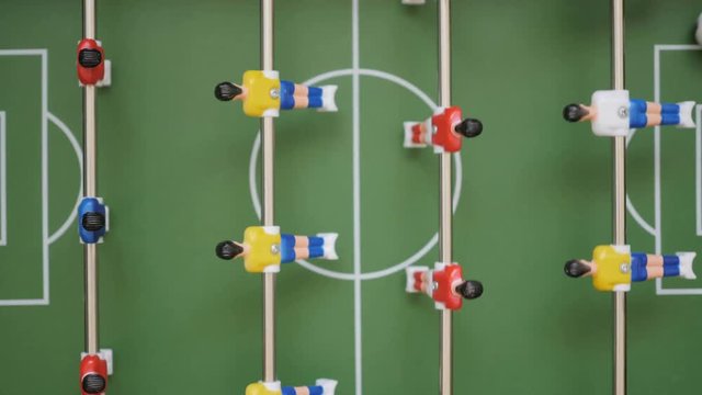 Friends Playing Table Soccer Game Closeup. People playing in table football or kicker with miniature players. Slow Motion. Shallow DOF. Playing Football Soccer on game table. Close Up.