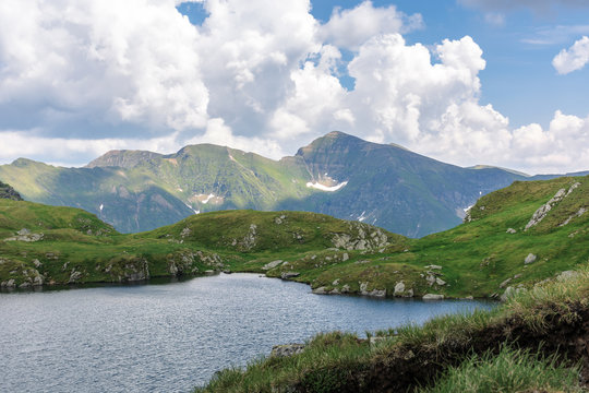 alpine glacier capra of fagaras mountains. gorgeous summer landscape. good weather with clouds on the sky. rocks on the grassy slopes. popular travel destination of romania