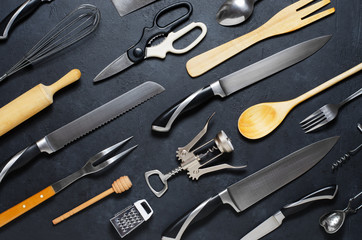 Wooden and metal kitchen utensils. Tools for cooking. Dark background. Flat lay