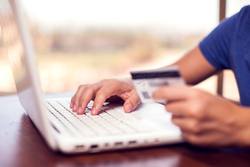 Woman holds credit card and makes online payment. Online shopping concept