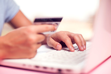 Woman holds credit card and makes online payment. Online shopping concept