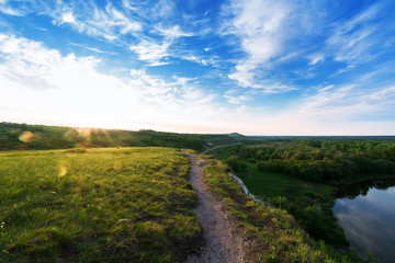 Obraz premium panorama of the river at sunset. the highlands, the sun's rays