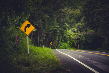 Traffic alerts downhill slope. Reduce speed and use a lower gear.arrow traffic sign with blue sky.warning sign on the street.