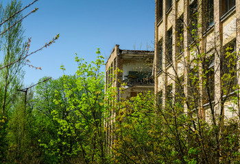 Fototapeta na wymiar Pripyat, Ukraine - April 27 2019: Secondary school. Abandoned building in Pripyat. Sign Energetik on the roof of the building. Exclusion Zone, Chernobyl, Pripyat
