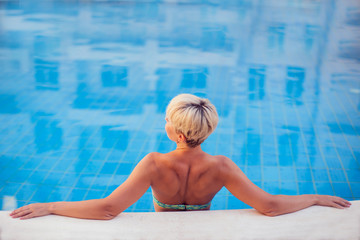 Woman spends time and has relax on the pool. People, travel, summer and holiday concept