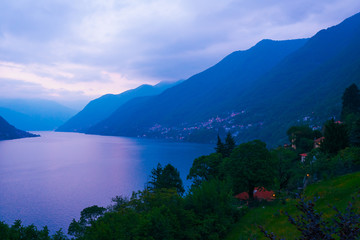 Mountain view with a lake at sunset in purple colors