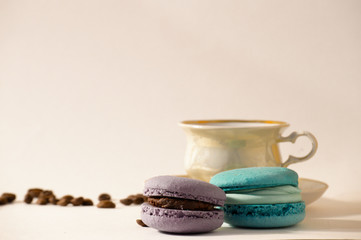 Delicious isolated macaroons with coffee beans and an aromatic cup of coffee