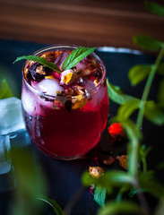 Close-up of homemade flower ice tea in a glass with fresh mint, on dark background