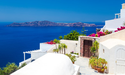 Fototapeta premium drzwi do hotelu na wzgórzu pośród białej architektury z widokiem na morze i kalderę, Santorini, Grecja