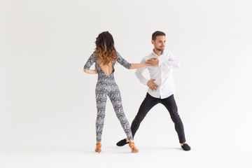 Social dance, bachata, kizomba, tango, salsa, people concept - Young couple dancing over white background with copy space