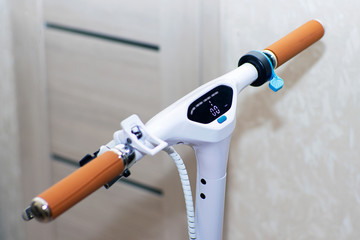 Electric scooter white with a control panel. Scooter steering wheel with brown leather handles....