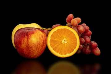 Naklejka na ściany i meble Orange, grapes, apple and pyrus pyriflora on a black background.