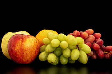 Orange, grapes, apple and pyrus pyriflora on a black background.