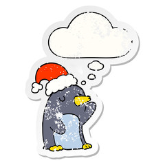 cute cartoon christmas penguin and thought bubble as a distressed worn sticker
