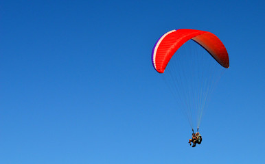 paraglider flying on the blue sky