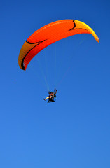 paraglider flying on the blue sky