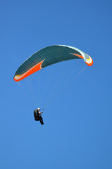 paraglider flight through the blue sky