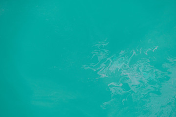 Oil spill on sea water, dirty sea pollution, beach pollution concep. Layer of leaked oil from the boat, ship create a rainbow on surface water background. Surface of seawater pollute the environment