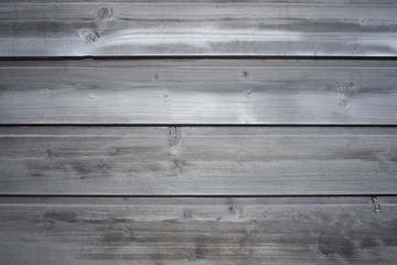 Naklejka premium Old wooden surface of tightly nailed planks with cracks and knots. Grey background close-up. Selective focus. Copy space.