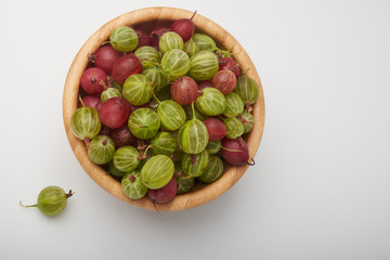 Gooseberries fruits on white background. Bowls with gooseberries isolated on white background. Red and green gooseberries in a bowl with copy space for text. Ripe gooseberry close-up.  K