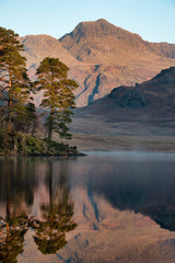 Beautiful Autumn Fall colorful sunrise over Blea Tarn in the Lake District with High Raise and The Langdales in the distance