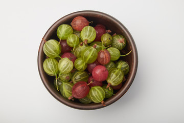 Gooseberries fruits on white background. Bowls with gooseberries isolated on white background. Red and green gooseberries in a bowl with copy space for text. Ripe gooseberry close-up.  K