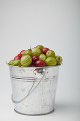 Gooseberries fruits on white background. Bowls with gooseberries isolated on white background. Red and green gooseberries in a bowl with copy space for text. Ripe gooseberry close-up.  K