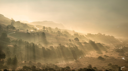 Beautiful Autumn Fall landscape sunrise in the Lake District with sun rays streaming through the...