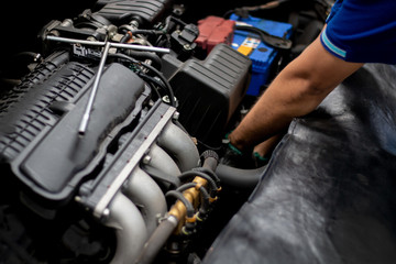 Obraz na płótnie Canvas Mechanic checking the car engine in auto repair