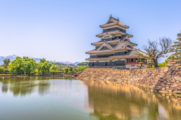 Fototapeta na wymiar Matsumoto - May 25, 2019: The castle of Matsumoto and the red bridge leading to it, Japan