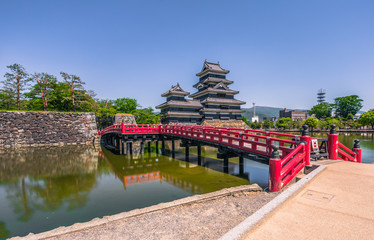 Obraz premium Matsumoto - May 25, 2019: The castle of Matsumoto and the red bridge leading to it, Japan