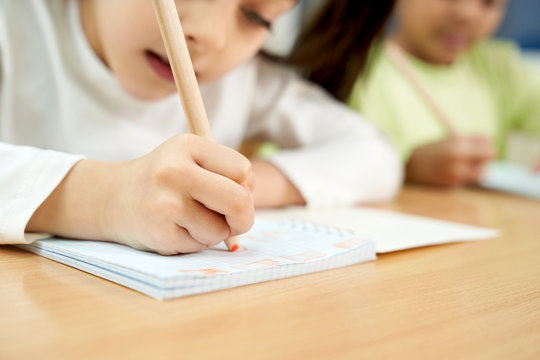 Concentrated Girl In Process Of Writing In Notebook