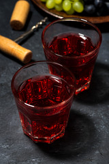 two glasses of red young wine on a dark table, vertical