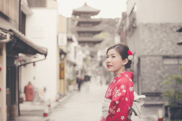 Asian woman wearing traditional Japanese kimono walking in the old town of Kyoto, Japan