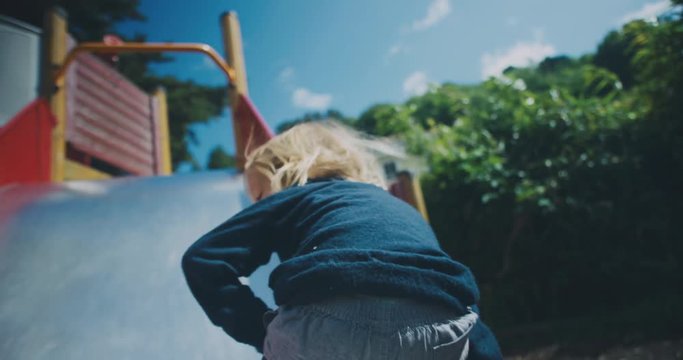 Handheld point of view shot of going down slide with toddler