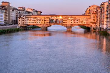 Obraz premium A view of the Arno River and the Ponte Vecchio in Florence, Italy.
