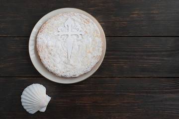 Fototapeta na wymiar Tarta de Santiago (St. James cake) famous spanish almond cake typically made in Galicia. It is usually decorated with powdered sugar creating a silhouette cross of Santiago.