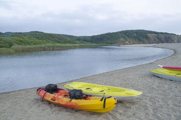 Two types of kayak two-seat sit-on-top  on the sandy bank of the river Veleka, Bulgaria