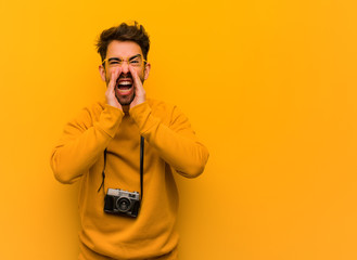 Young photographer man shouting something happy to the front