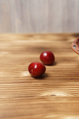 Red sweet cherry in a clay plate on a wooden table