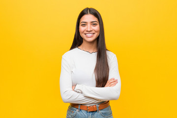 Young pretty arab woman against a yellow background who feels confident, crossing arms with...