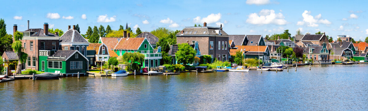 Panorama with row of old dutch green traditional houses in town Zaanse Schans/ Zaandijk in Netherlands, North Holland near Amsterdam