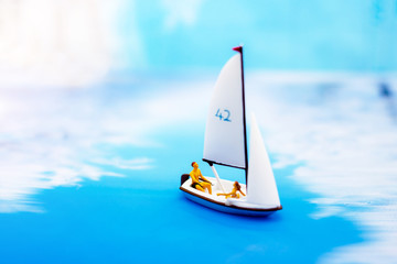 Miniature people: Faminly with balloon on board of sea boat. Summer concept.