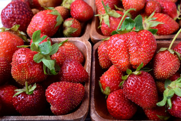 Fresh organic strawberries in little wooden bowls