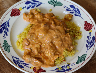 Indian chicken tandoori sauce with yellow rice on a plate