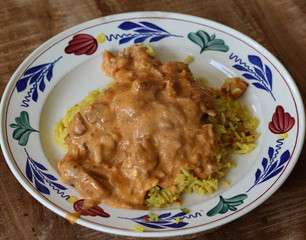 Indian chicken tandoori sauce with yellow rice on a plate