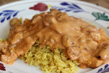 Indian chicken tandoori sauce with yellow rice on a plate